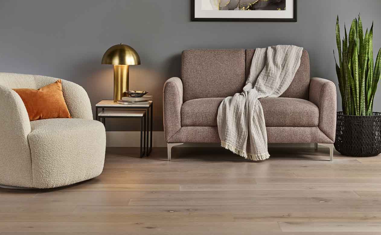 Hardwood flooring in a living room with loveseat and beige accent chair