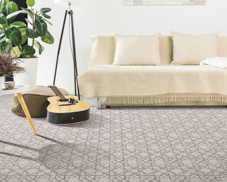 Pretty sofa, with guitar nearby on patterned carpeting