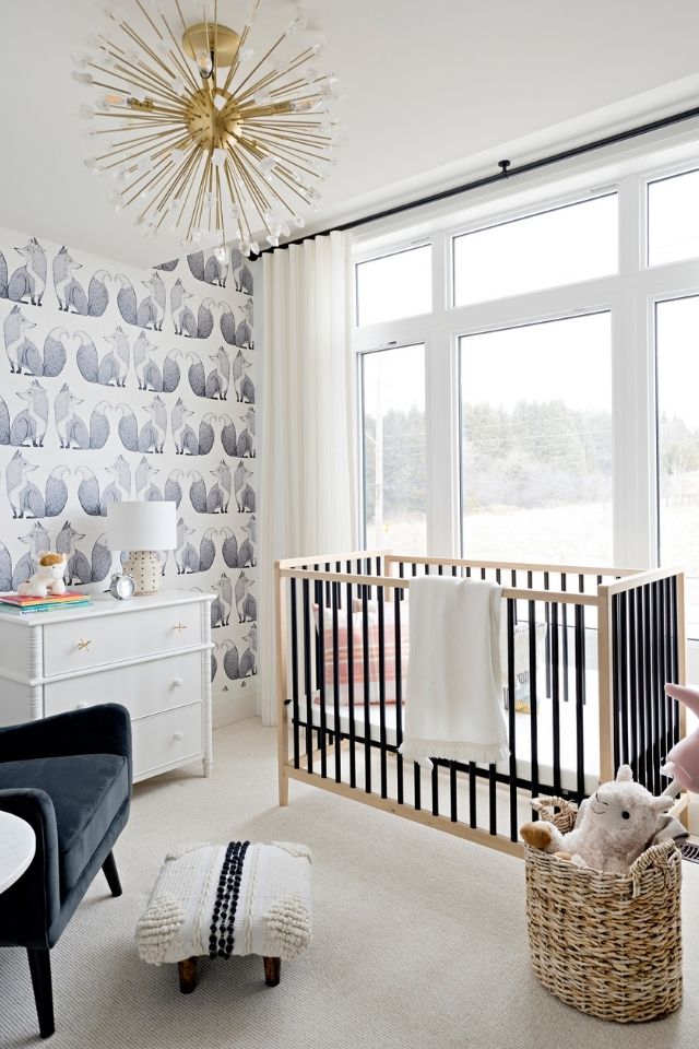 Trendy nursery room with wallpaper and large windows