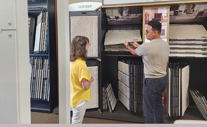 Friendly and knowledgeable flooring expert showing sample to customer.
