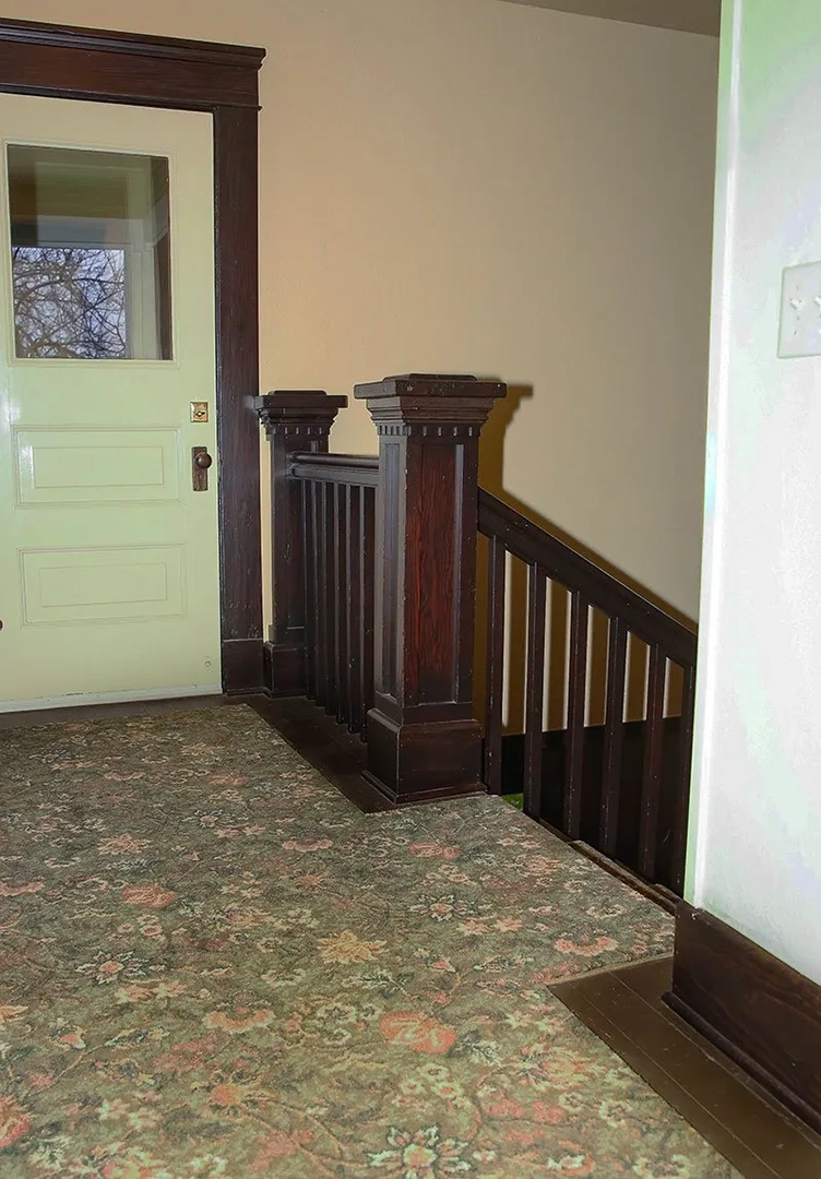 Stairway landing with green and pink floral carpeting