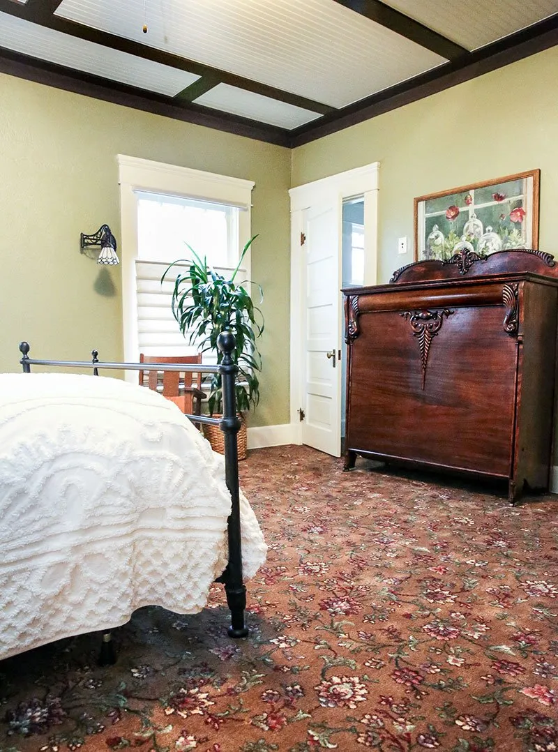 Bedroom with cranberry, green, and ivory floral carpet