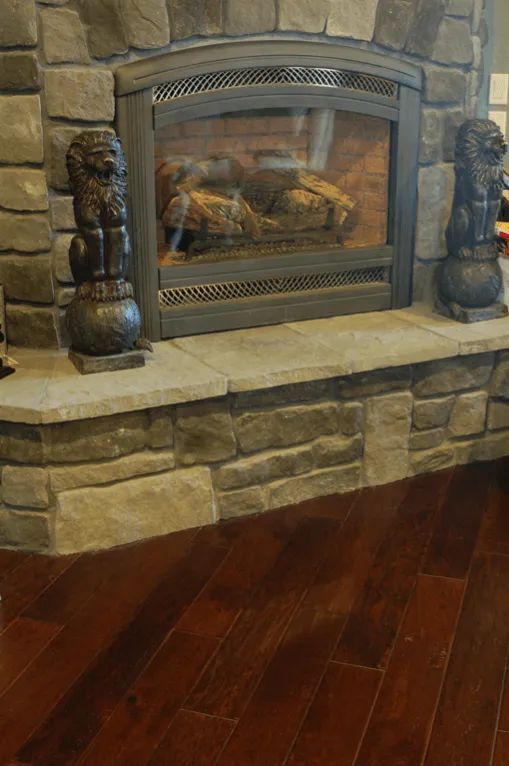 Stone fireplace next to handscraped hardwood floor