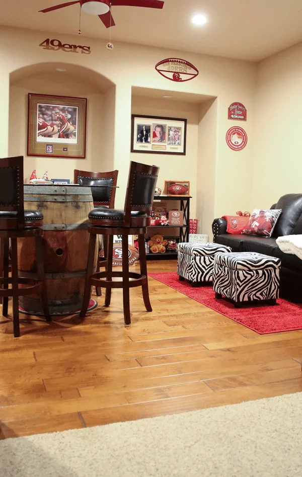 Seating area in sports room with leather sofa and animal print ottomans
