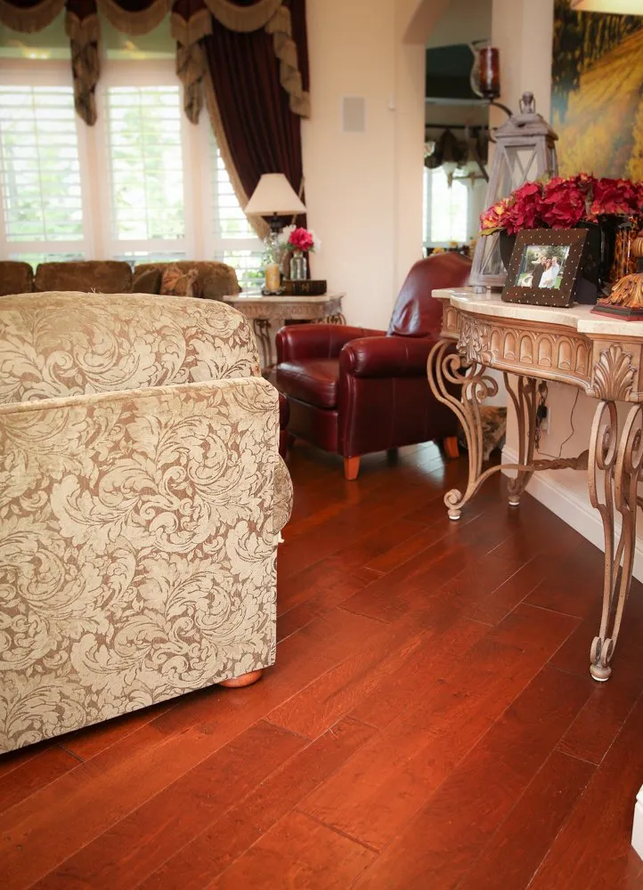 Side table and back of upholstered chair on hardwood flooring